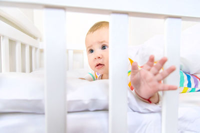 Portrait of cute baby boy sleeping on bed at home