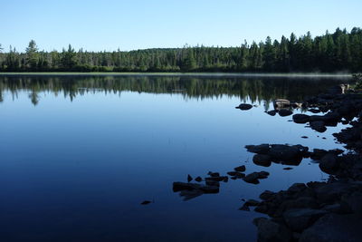 Scenic view of lake against clear blue sky