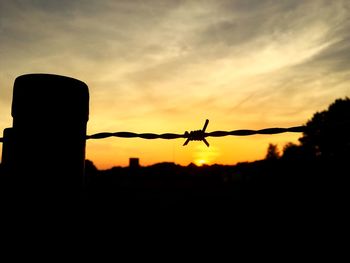 Silhouette airplane against sky during sunset