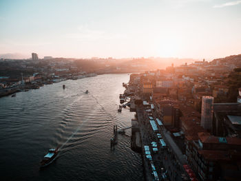 High angle view of city at river during sunset