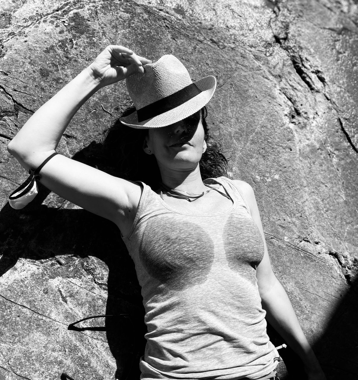 white, black, one person, black and white, adult, sun hat, monochrome photography, leisure activity, hat, lifestyles, monochrome, day, casual clothing, young adult, women, clothing, nature, person, outdoors, fashion accessory, fashion, standing, photo shoot, sunlight, waist up, wall - building feature, portrait, rock, activity, three quarter length, front view, female, looking