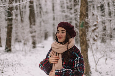 Beautiful young woman enjoying a wonderful winter day in the forest. 