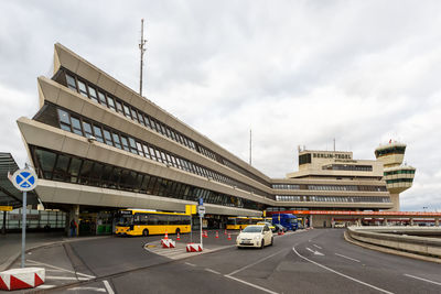 Cars on road by buildings against sky