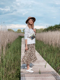 Full length of woman standing on field against sky