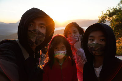 Portrait of friends against sky