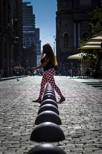 Woman on street in city against sky