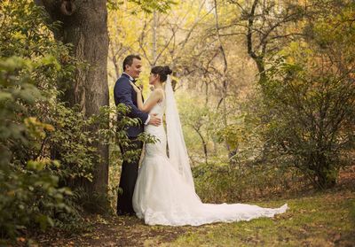 Young couple kissing against trees and plants