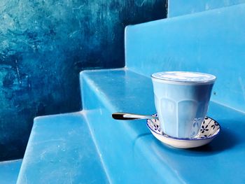 Close-up of drink on table against blue wall