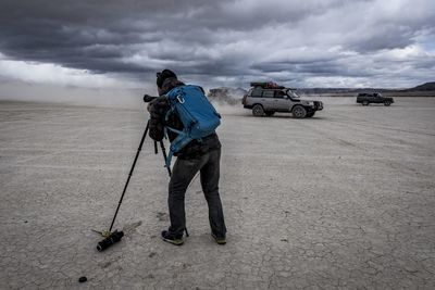 Full length of man skateboarding on landscape against sky