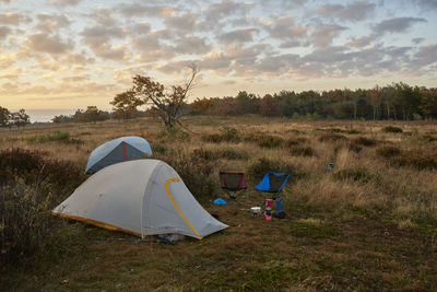 Tent on field against sky during sunset