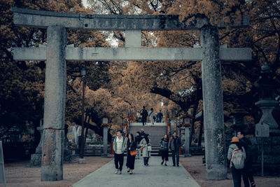 Group of people walking by tree in city