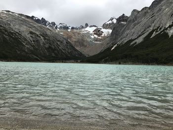 Scenic view of lake by mountains against sky