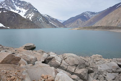 Scenic view of lake by mountains against sky