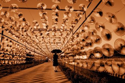 Low angle view of man walking on illuminated ceiling