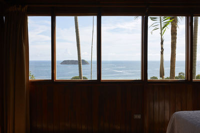 Scenic views of the sea from inside the wooden bedroom through the windows