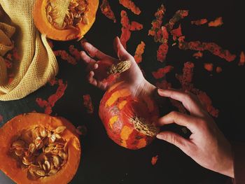 High angle view of hands holding orange