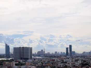 Buildings in city against cloudy sky