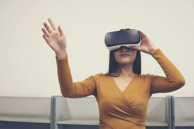 Young woman gesturing while wearing virtual reality simulator