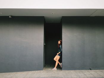 Woman leaning on wall in city