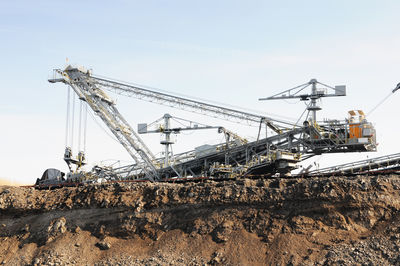 Cranes at construction site against sky