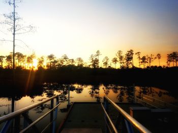 Silhouette trees against clear sky during sunset