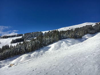 Snow covered mountain against blue sky