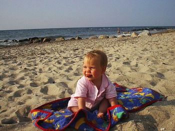 Rear view of man sitting on beach