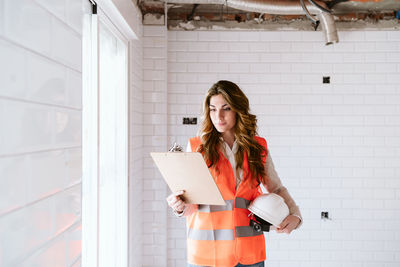 Inspector or architect professional woman checking kitchen at construction site. home improvement