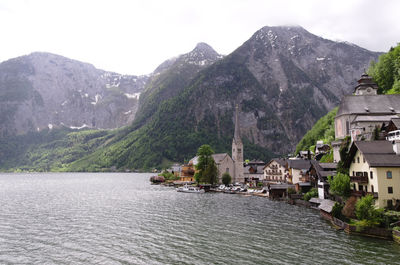 Town by lake and mountains against sky