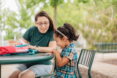 Young millennial mother sending daughter off back to school