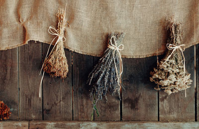 Various herbs hang to dry on a wooden wall