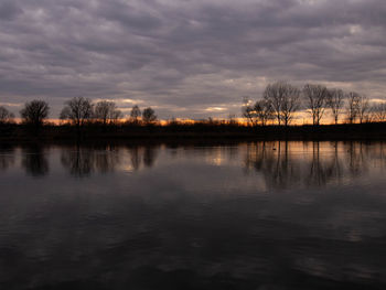 Scenic view of lake against sky at sunset