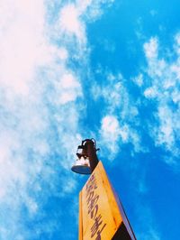 Low angle view of sign against blue sky