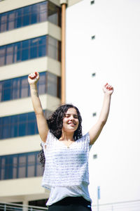 Smiling teenage girl against building in city