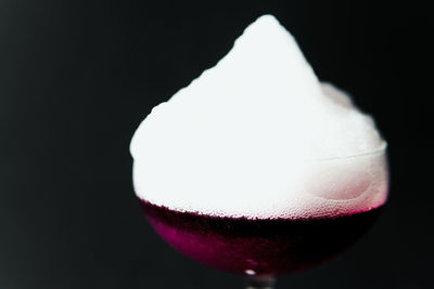 Close-up of beer glass against black background