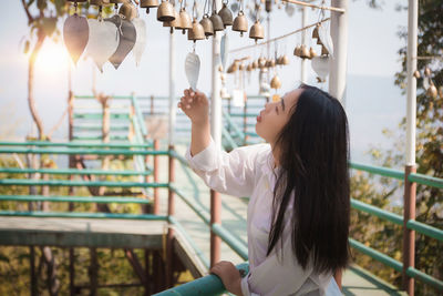 Side view of young woman holding umbrella