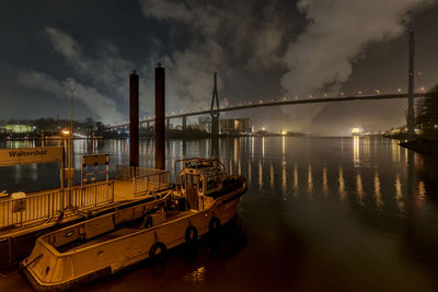 View of suspension bridge over river against cloudy sky