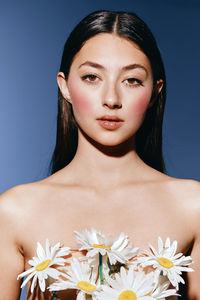 Portrait of young woman against pink background