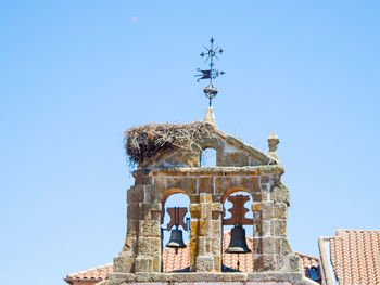 Low angle view of bell tower against clear blue sky