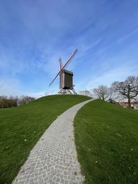 Traditional windmill on field against sky