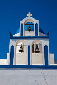 Low angle view of bell tower against blue sky