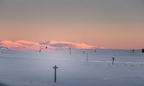 Scenic view of snow covered mountains against sky at sunset