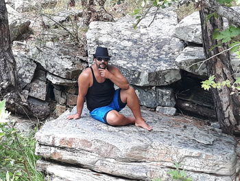 Young man sitting on rock