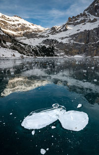 Scenic view of frozen lake by snowcapped mountains