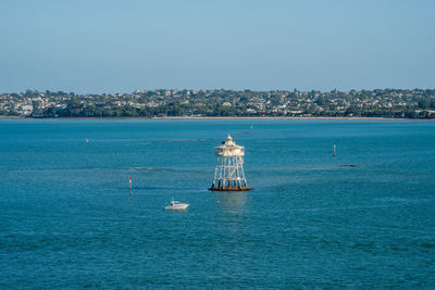 Sailboat sailing on sea against clear blue sky