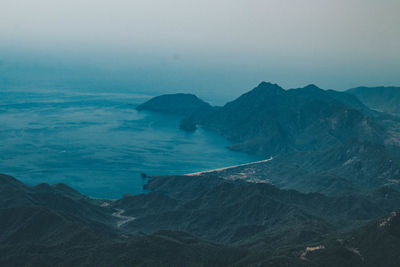 Scenic view of sea and mountains against sky