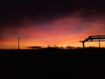 Scenic view of silhouette field against sky during sunset