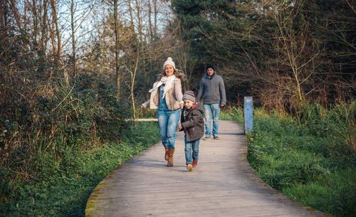 Women walking on footpath amidst plants
