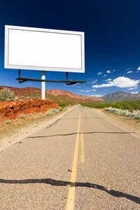 Road sign against blue sky