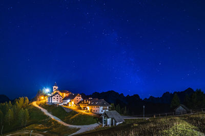 Illuminated buildings against sky at night